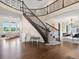 Grand foyer with a curved staircase, hardwood floors, and views of the living and dining areas at 8425 Green Island Cir, Lone Tree, CO 80124