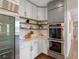 Modern kitchen features built-in ovens, wood shelving and white countertops and cabinets at 8425 Green Island Cir, Lone Tree, CO 80124