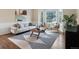 Bright living room featuring large windows, a comfortable sofa, and a stylish geometric rug at 8425 Green Island Cir, Lone Tree, CO 80124