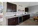 This wet bar features dark wood cabinets, a wine cooler, and sleek white subway tile at 8425 Green Island Cir, Lone Tree, CO 80124