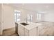 Open concept kitchen with island, stainless steel sink, and white cabinets at 5581 Wisteria Ave, Firestone, CO 80504