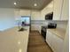 Bright kitchen with white cabinets, quartz countertops, and stainless steel appliances at 5581 Wisteria Ave, Firestone, CO 80504