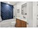 Stylish bathroom with navy blue tile in herringbone pattern, modern vanity, and a shower-tub combo at 2341 Poze Blvd, Thornton, CO 80229