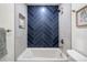 Modern bathroom featuring a tub with blue herringbone tile, a shower head, and neutral paint at 2341 Poze Blvd, Thornton, CO 80229