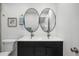 Bathroom featuring a double sink vanity, two mirrors and modern fixtures at 2341 Poze Blvd, Thornton, CO 80229