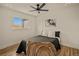 Cozy bedroom featuring light wood floors, a ceiling fan, and a bright window at 2341 Poze Blvd, Thornton, CO 80229