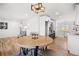 Open-concept dining area with modern light fixture, round wood table, and seating for four at 2341 Poze Blvd, Thornton, CO 80229