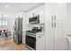 Modern kitchen with stainless steel appliances, white cabinets, and marble backsplash at 2341 Poze Blvd, Thornton, CO 80229