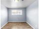 This bedroom offers light-blue walls, wood-look floors, and a window with blinds at 1155 S Fairplay Cir # D, Aurora, CO 80012