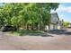 A view of the townhouse, with mature trees, and a car parked in front at 1155 S Fairplay Cir # D, Aurora, CO 80012