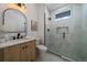 Modern bathroom with grey floors, marble vanity, and a glass enclosed shower and window at 3315 N Josephine St, Denver, CO 80205