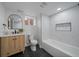 Basement bathroom with black floor tiles, wood vanity and a modern shower and tub at 3315 N Josephine St, Denver, CO 80205