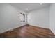 An empty bedroom with wood floors, white walls, a window, white door, and base molding at 3315 N Josephine St, Denver, CO 80205