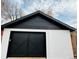 A detached garage featuring a modern black garage door and white brick and siding for a clean, contemporary look at 3315 N Josephine St, Denver, CO 80205