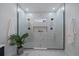 Modern shower with grey tile floor, glass enclosure, white marble tiled walls and built in shelving at 3315 N Josephine St, Denver, CO 80205