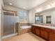 Bathroom featuring double vanity, soaking tub, and glass shower at 8983 E Nichols Pl, Centennial, CO 80112
