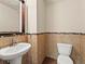 Stylish powder room featuring tiled walls, pedestal sink and decorative mirror at 8983 E Nichols Pl, Centennial, CO 80112