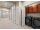 Convenient laundry room equipped with modern appliances and cabinet storage at 8983 E Nichols Pl, Centennial, CO 80112