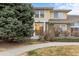 Exterior view showcasing the home's curb appeal with mature trees and manicured lawn at 3000 E 112Th Ave # 102, Northglenn, CO 80233