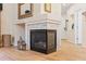 Modern fireplace with white tile surround, wooden mantel, and decorative accessories at 3000 E 112Th Ave # 102, Northglenn, CO 80233