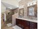 Bathroom featuring double sinks, a stone accent wall, and a glass-enclosed shower with custom tile at 8387 N Sunburst Trl, Parker, CO 80134