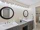 Bright bathroom with dual sinks, large mirrors, vanity area, and contemporary lighting fixtures at 8387 N Sunburst Trl, Parker, CO 80134