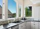 Bright kitchen with black countertops, tiled backsplash and custom windows with nice views at 8387 N Sunburst Trl, Parker, CO 80134