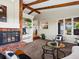Cozy living room with a brick fireplace, exposed wood beams, and an open view into the kitchen at 8387 N Sunburst Trl, Parker, CO 80134
