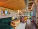 Spacious living area with vaulted wood ceiling, exposed brick wall, and comfortable seating at 8387 N Sunburst Trl, Parker, CO 80134