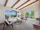 Inviting living room with exposed wood beams, large windows with views, and a brick fireplace at 8387 N Sunburst Trl, Parker, CO 80134