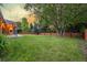 Spacious backyard with a well-kept lawn, patio, privacy fence, and mature trees at 2644 S Krameria St, Denver, CO 80222