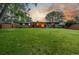 Large backyard featuring a well-maintained lawn, privacy fence, brick home, and mature trees at 2644 S Krameria St, Denver, CO 80222