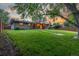Spacious backyard featuring a well-manicured lawn, mature trees, and a brick house exterior at 2644 S Krameria St, Denver, CO 80222