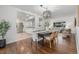 Open dining area with hardwood floors, modern chandelier, and seamless flow into the living room and kitchen at 2644 S Krameria St, Denver, CO 80222