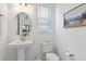 Well-lit powder room with pedestal sink, modern fixtures, and a decorative mirror at 1369 E Witherspoon Dr, Elizabeth, CO 80107