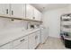 Modern laundry room with white cabinets, sink, and stainless steel washer and dryer at 1369 E Witherspoon Dr, Elizabeth, CO 80107