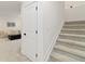 Carpeted staircase leading to a finished basement with access door and hallway at 1369 E Witherspoon Dr, Elizabeth, CO 80107