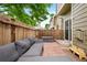 Relaxing brick patio featuring a comfortable gray sofa, storage bench, and wooden fence at 9138 Gale Blvd # 2, Thornton, CO 80260
