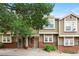 Charming townhome featuring a brick facade and mature trees, creating a welcoming curb appeal at 9138 Gale Blvd # 2, Thornton, CO 80260