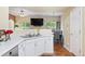 Well-lit kitchen with white cabinets, stainless sink, and view to dining area at 9138 Gale Blvd # 2, Thornton, CO 80260
