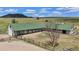 Aerial view of horse barn with a green roof and surrounding pastures at 6145 S Perry Park Rd, Sedalia, CO 80135