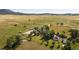 Aerial view of house and outbuildings surrounded by pasture and mountains at 6145 S Perry Park Rd, Sedalia, CO 80135