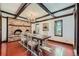 Elegant dining room featuring exposed beam ceilings, a brick fireplace and views to the exterior at 6145 S Perry Park Rd, Sedalia, CO 80135