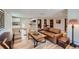 Bright living room with hardwood floors, a comfortable leather sofa, and a view into the kitchen at 6145 S Perry Park Rd, Sedalia, CO 80135