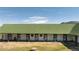 Horse stable with multiple stalls featuring a long green roof and ample outdoor space at 6145 S Perry Park Rd, Sedalia, CO 80135