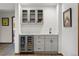 Lower level bar with custom cabinets, wine fridge and sink at 6145 S Perry Park Rd, Sedalia, CO 80135