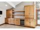 Home bar area with custom wood cabinets, granite countertop, and wine cooler at 5797 S Laredo Ct, Centennial, CO 80015