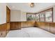 Cozy bedroom with wood paneling, plush carpeting, and three large windows at 5797 S Laredo Ct, Centennial, CO 80015