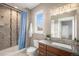 Bright bathroom with a tiled shower, modern vanity, and natural light from the window at 10145 Deerfield St, Firestone, CO 80504