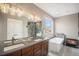 This primary bathroom features a double vanity, a soaking tub, and a fireplace at 10145 Deerfield St, Firestone, CO 80504